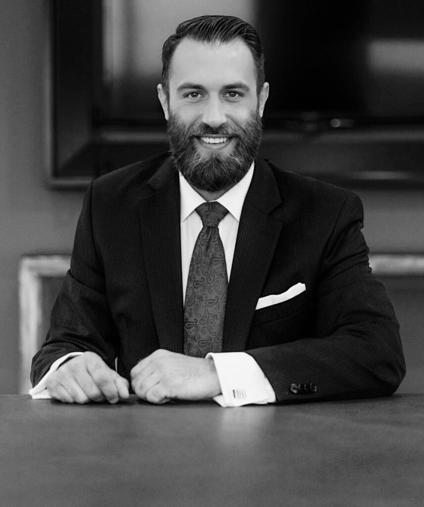 Michael J. Penney seated smiling at conference table, black and white photograph, Michael J. Penney, MJPenney