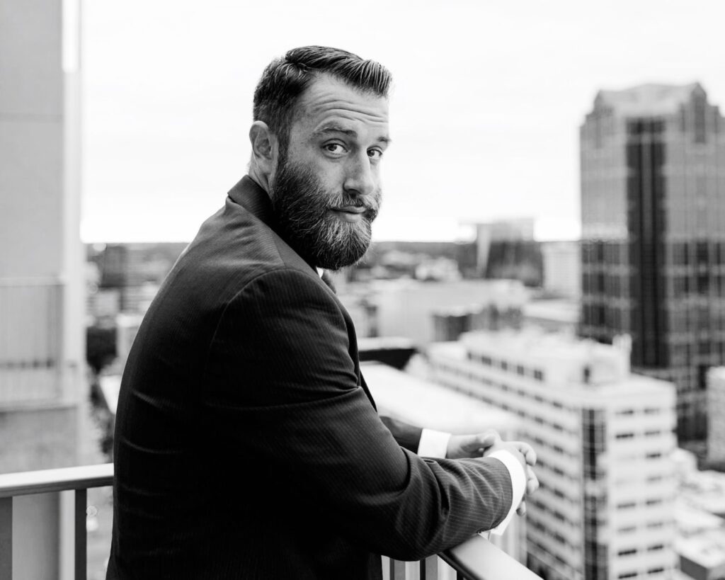 Michael J. Penney turning towards the camera over the city, black and white photo, Michael J. Penney, MJPenney